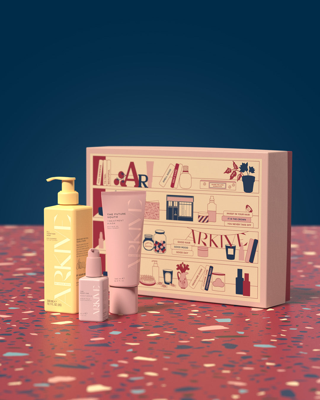 A gift set of Arkive products, including the Future Youth treatment mask, the Rootine calming scalp serum, and All Together co cleanser, laid out on a patterned table