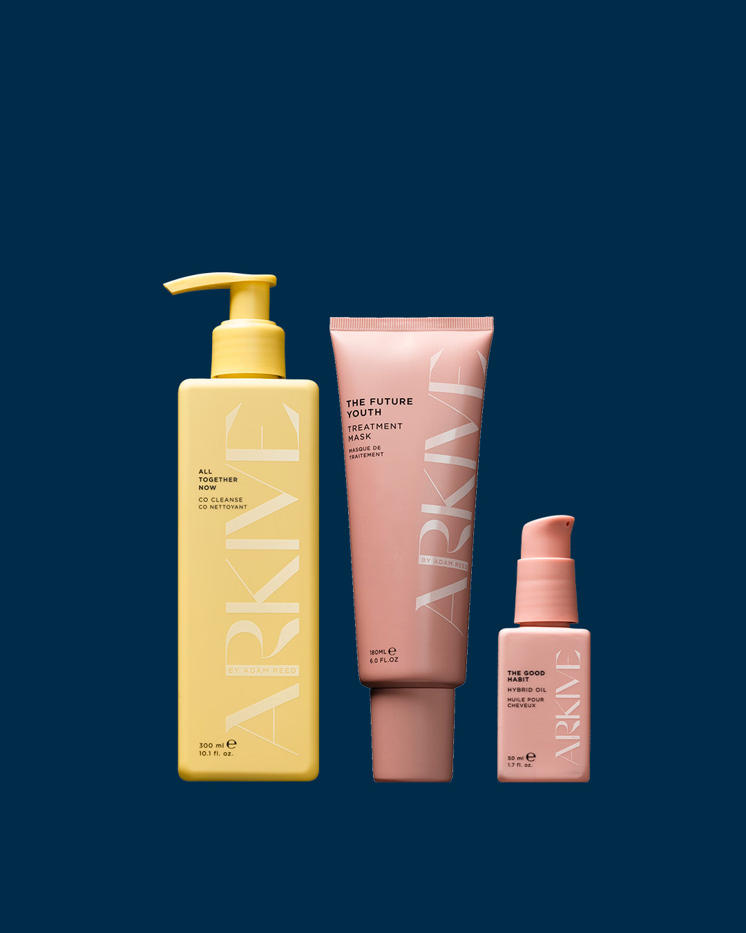 A gift set of Arkive products, including the Future Youth treatment mask, the Rootine calming scalp serum, and All Together co cleanser, laid out on a navy blue background