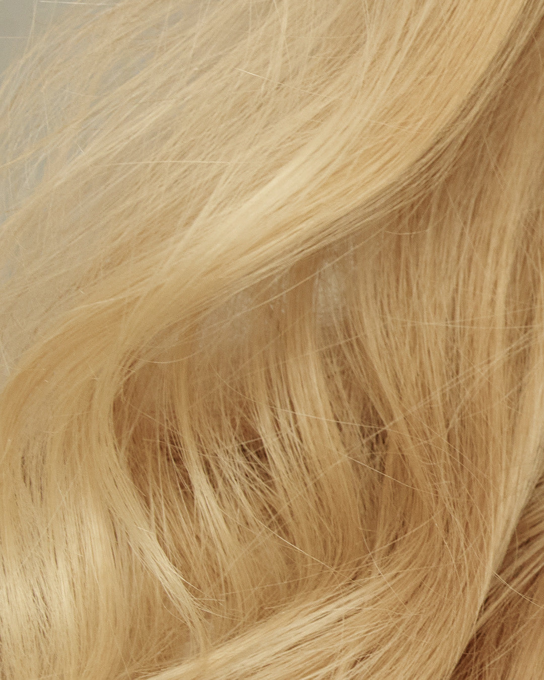 Close up of blonde hair full of volume and bouncy shine