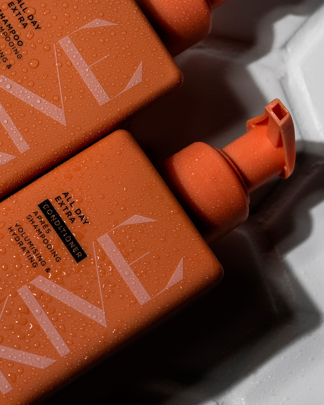 A bottle of Arkive's innovative gel cream conditioner lying next to the all day extra shampoo