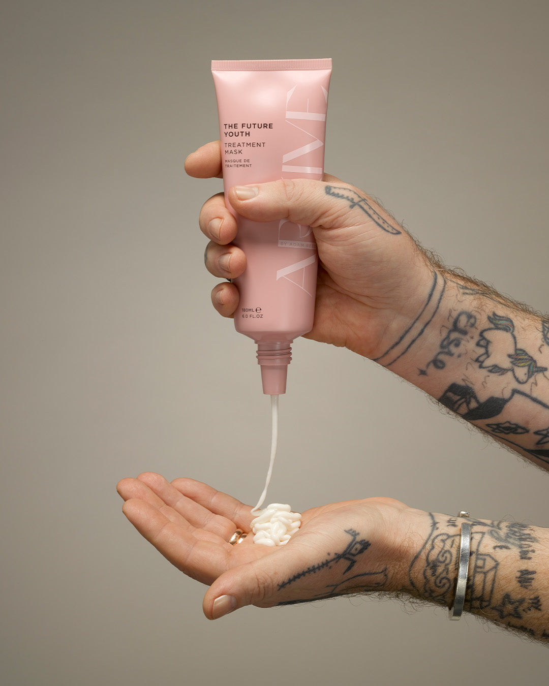 A bottle of Arkive's The Future Youth hair treatment mask being poured into the palm
