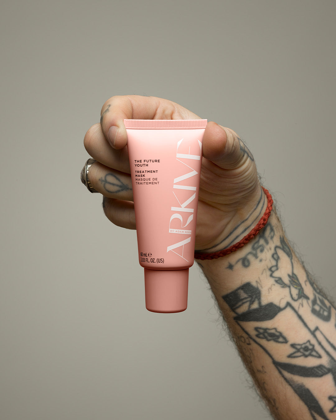 A 60ml mini bottle of Arkive's The Future Youth hair treatment mask held in the hand