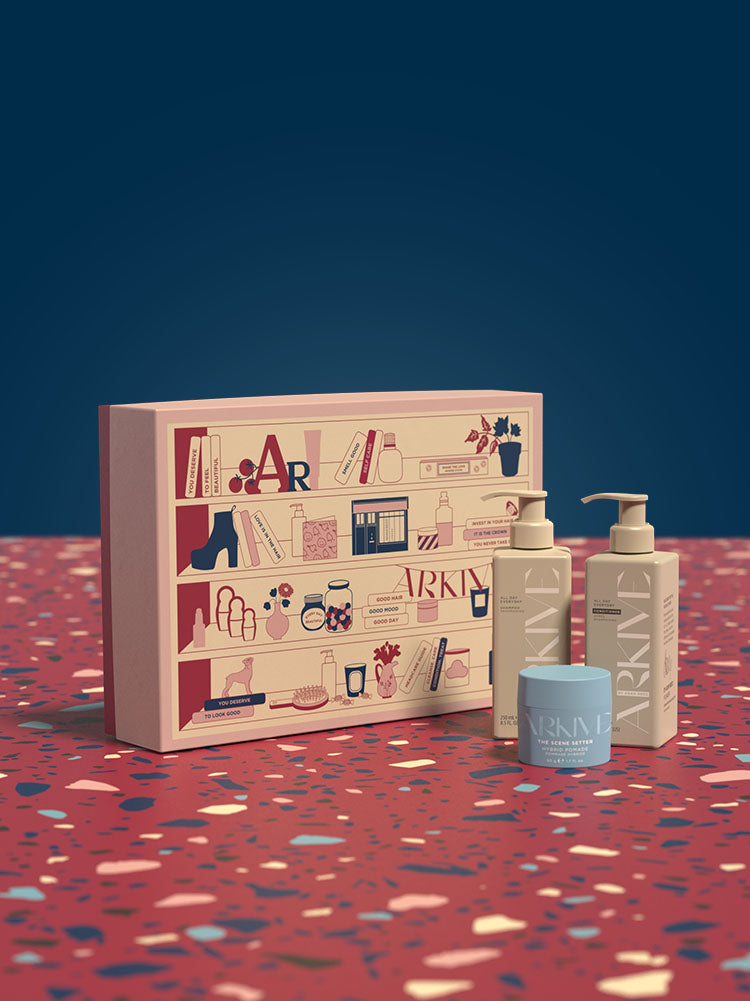 A gift set including the All Day Everyday hair shine enhancing Shampoo and Conditioner and The Scene Setter Hybrid Pomade on a patterned table